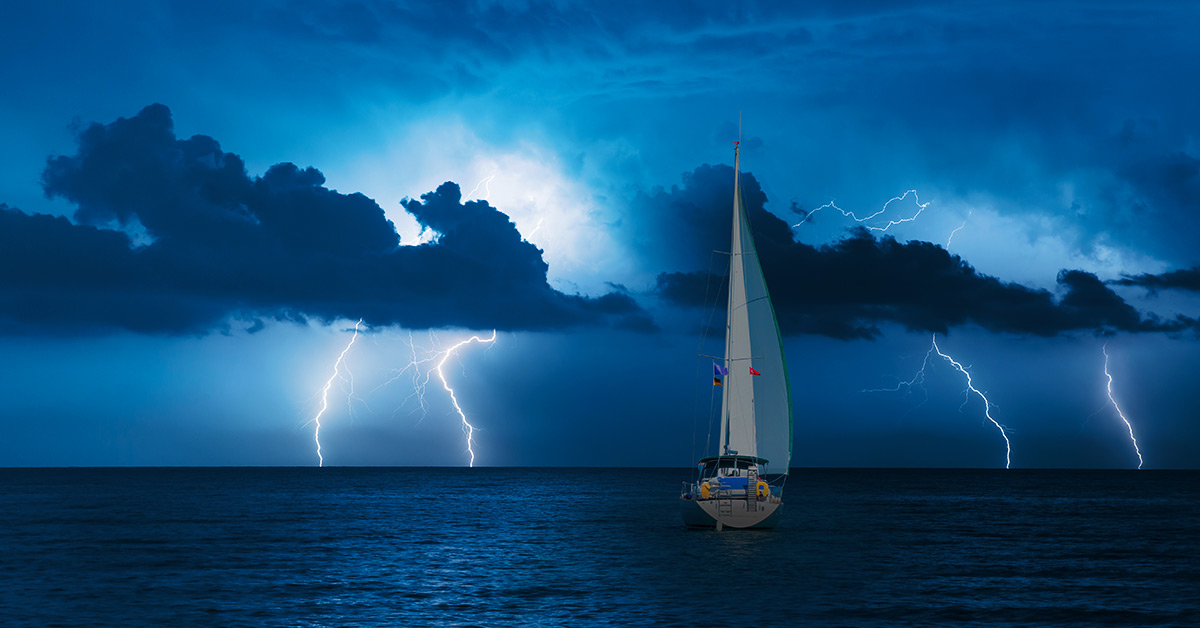 boat in the see in the middle of a lightning storm