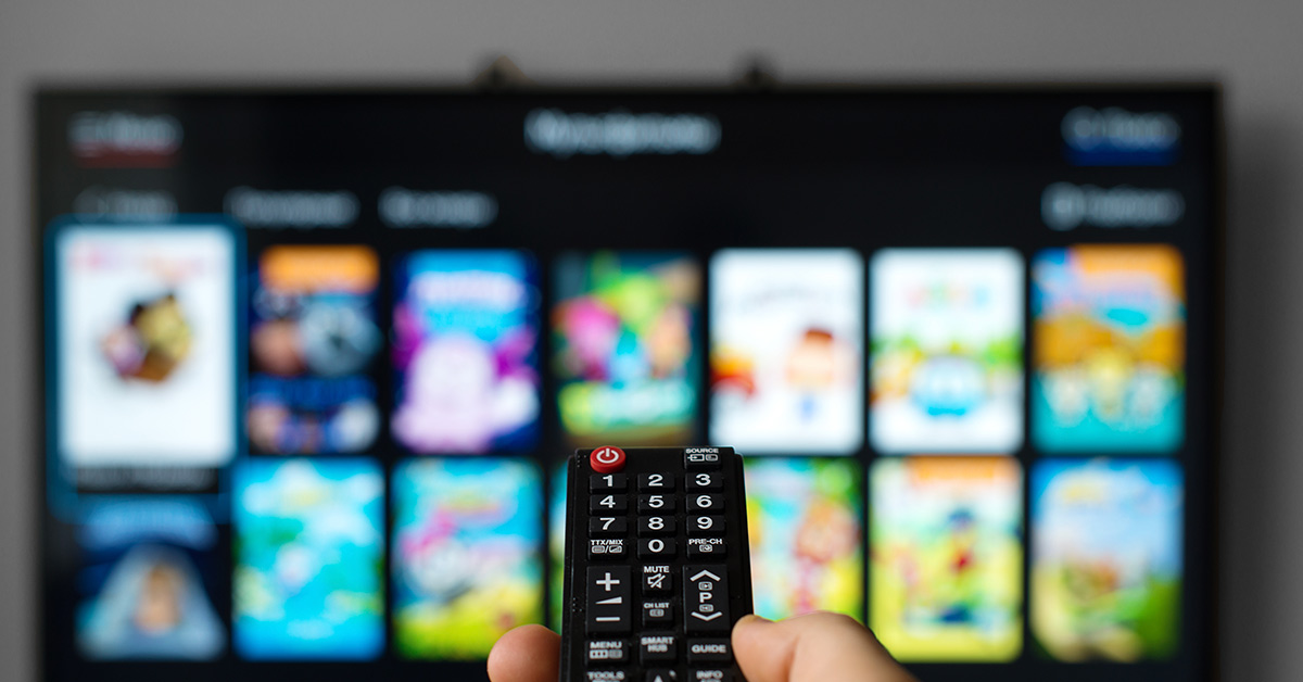 person pointing remote at smart tv