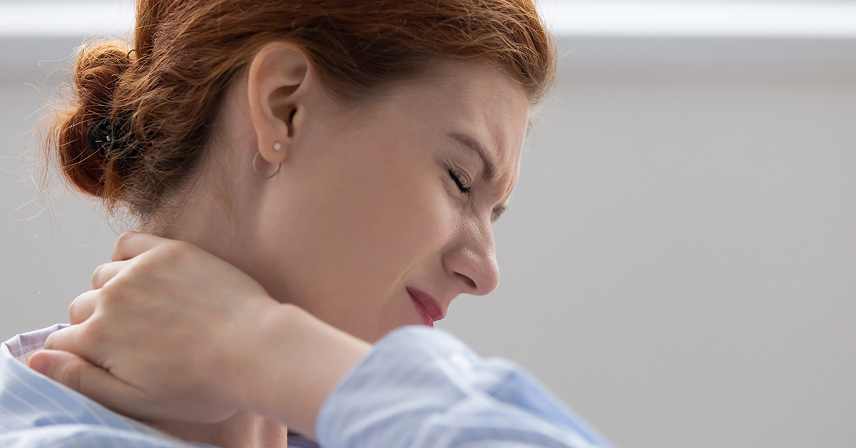woman feeling pain and holding the back of her neck