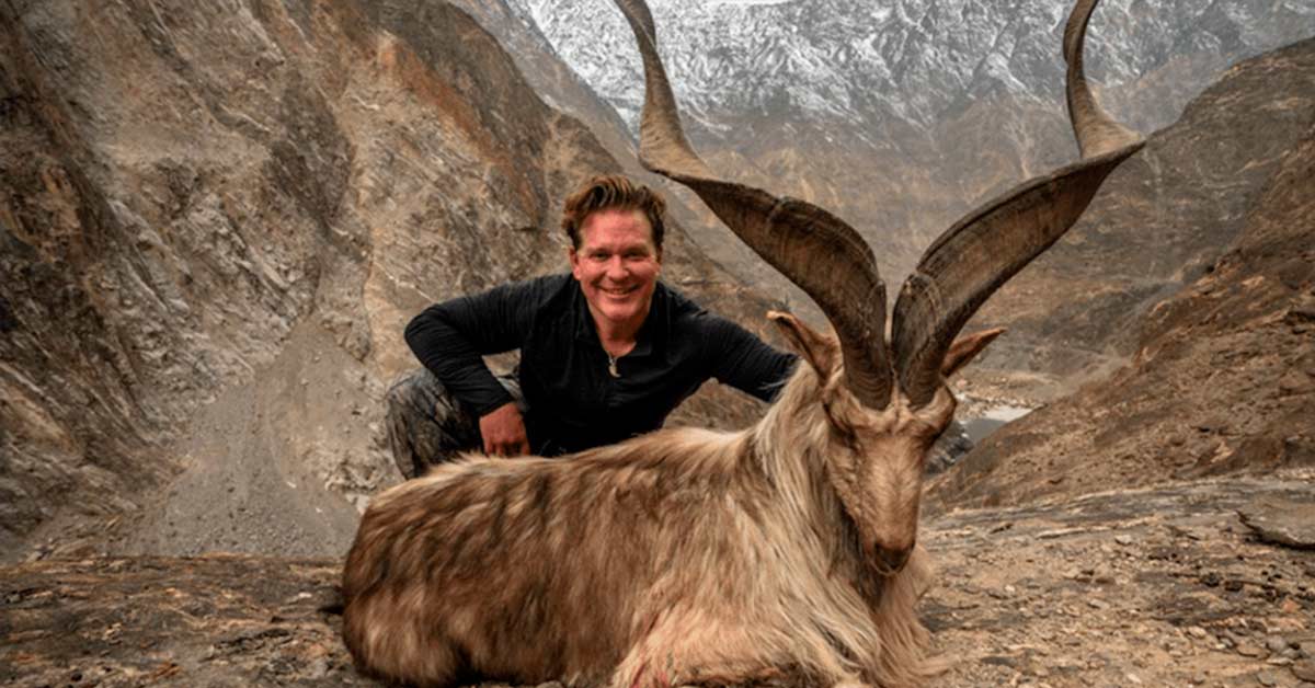 trophy hunter posing with rare mountain goat