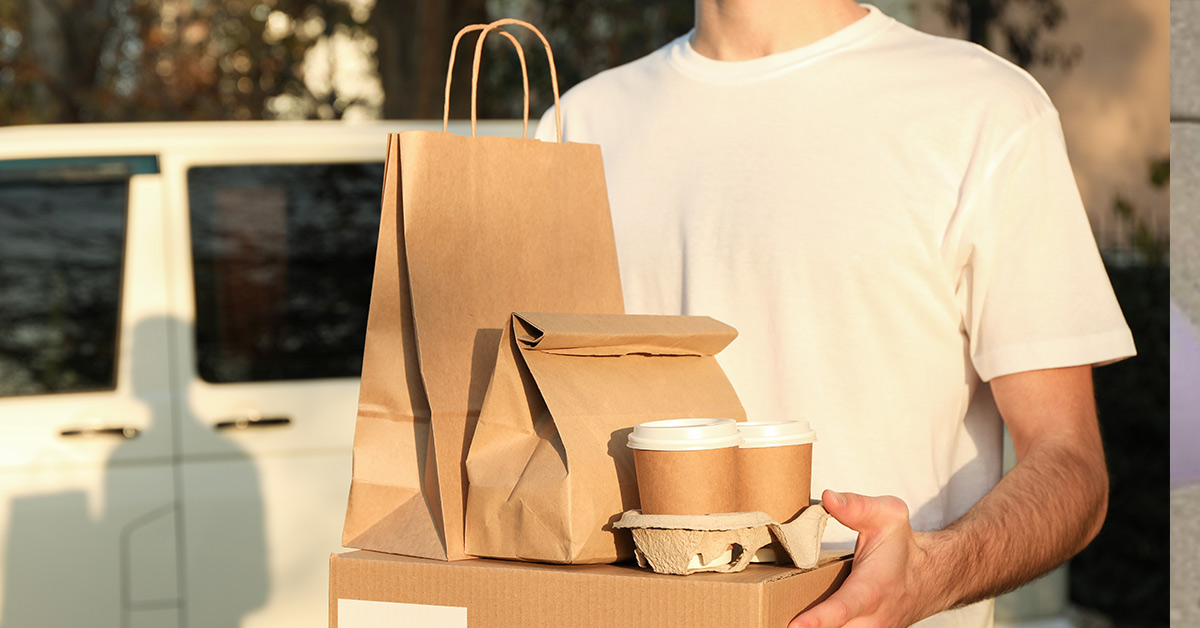 delivery driver holding take out food containers