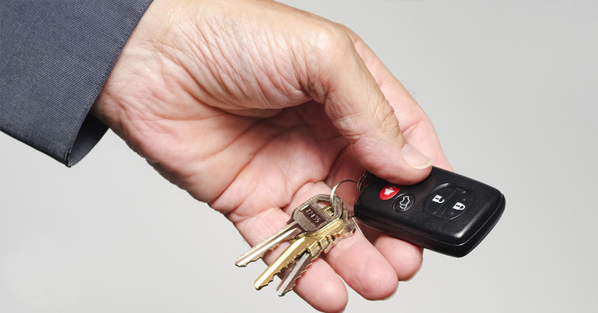 person holding a car key fob