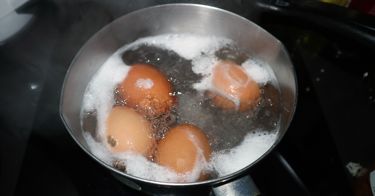 cracked eggs boiling in pot