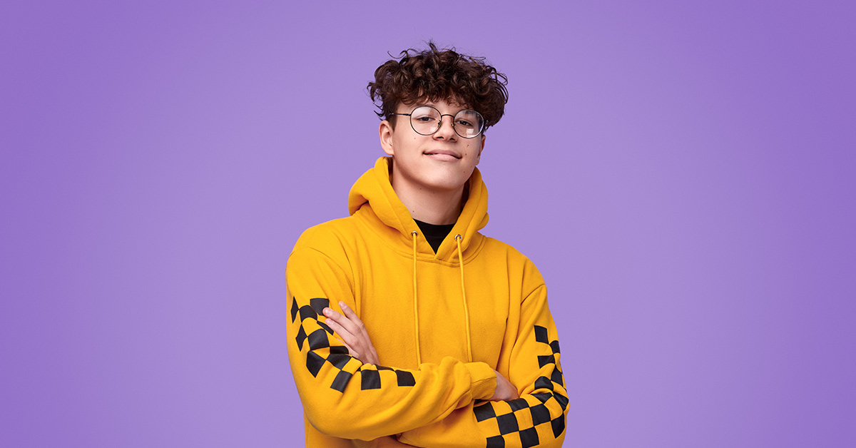 teenage boy wearing yellow hoodie with a purple background
