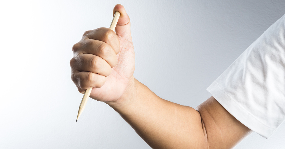 someone holding a pencil in a stabbing like fashion