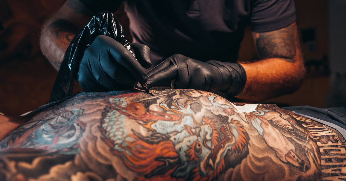 person receiving large tattoo, a type of body modification