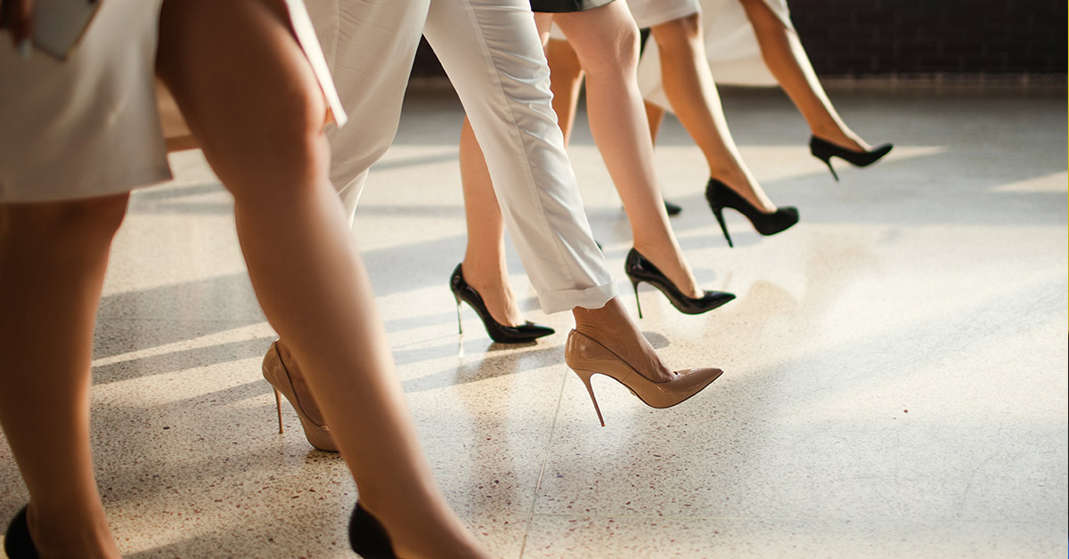 a line of 4 women walking confidently in heels