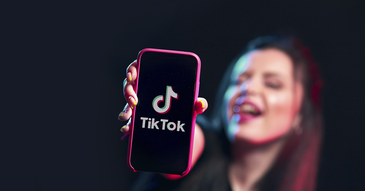 woman holding smartphone displaying TikTok