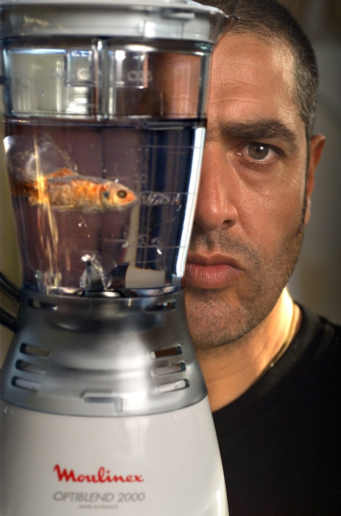 Marco Evaristti posing with a goldfish in a blender