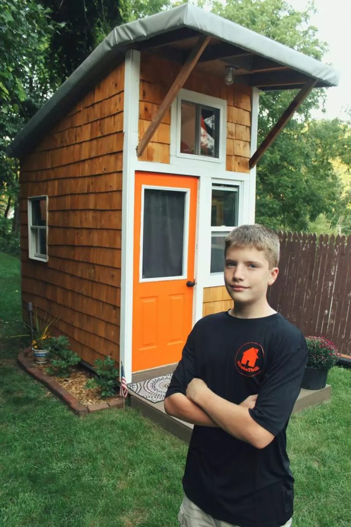Luke standing in front of his first tiny house.