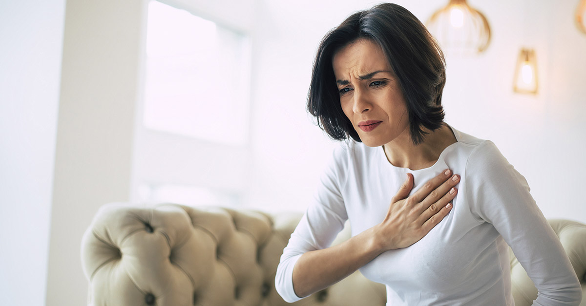 woman holding chest due to chest pain