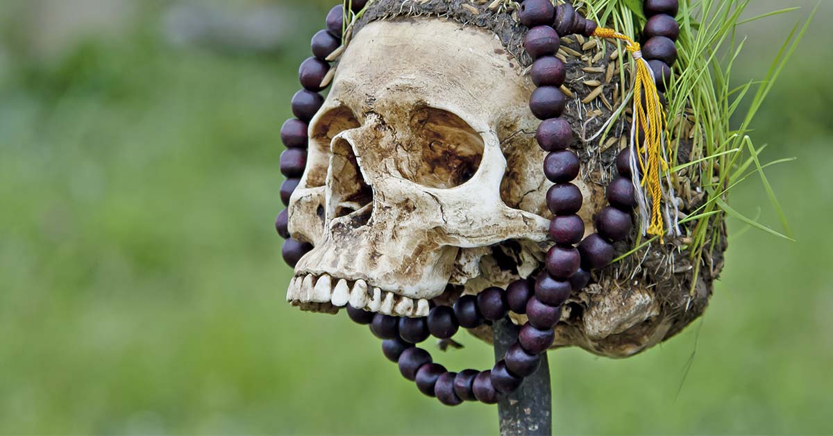 human skull with decorative beads wrapped around it