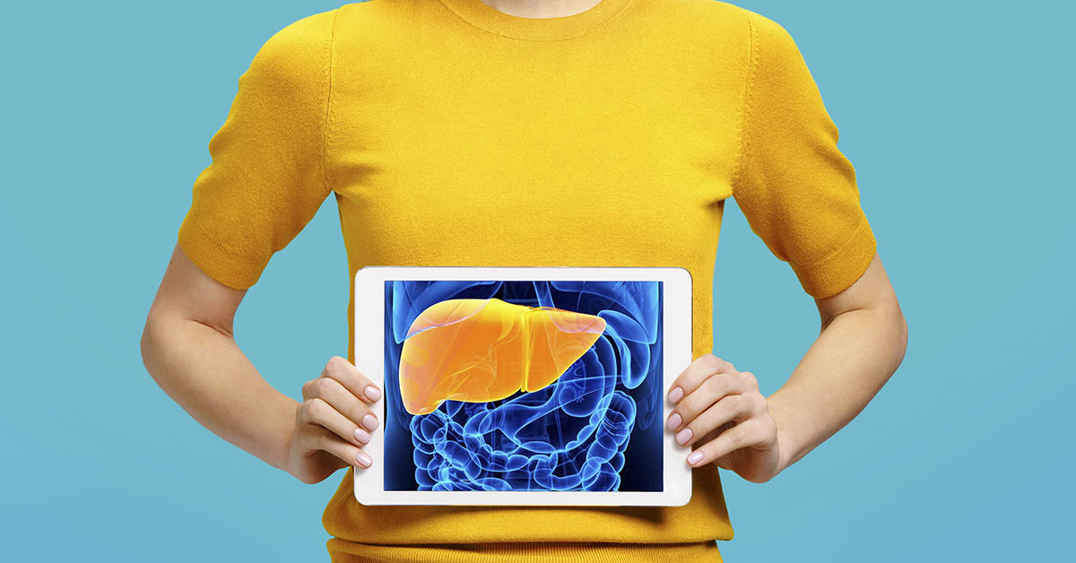 person in yellow shirt placing an illustration of a liver over abdomen