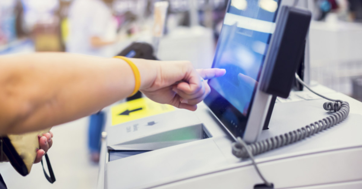 person operating self checkout machine