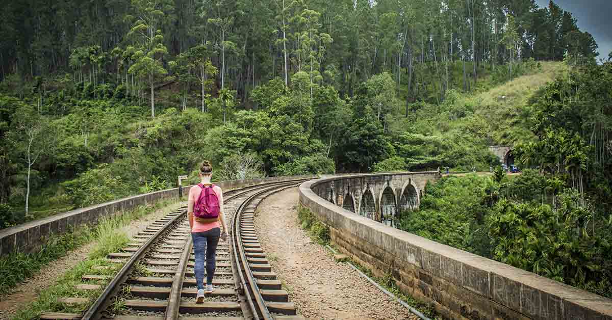 person hiking along train tracks in the wilderness
