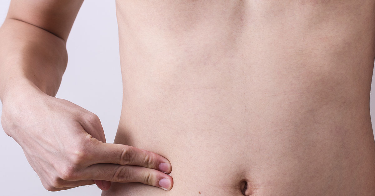 shirtless person touching area of their abdomen where their appendix is