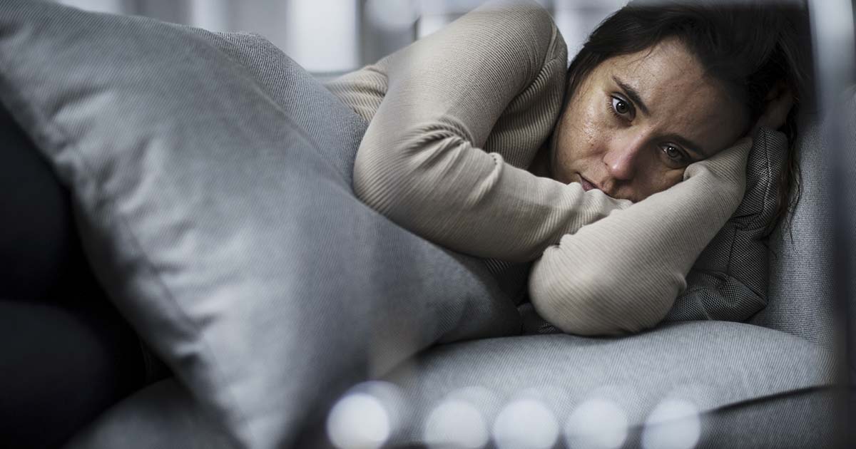 depressed woman laying in bed