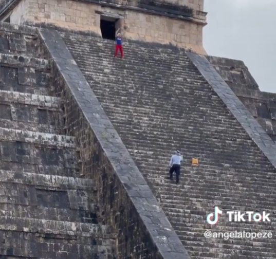 Tourist climbing Mayan pyramid stairs