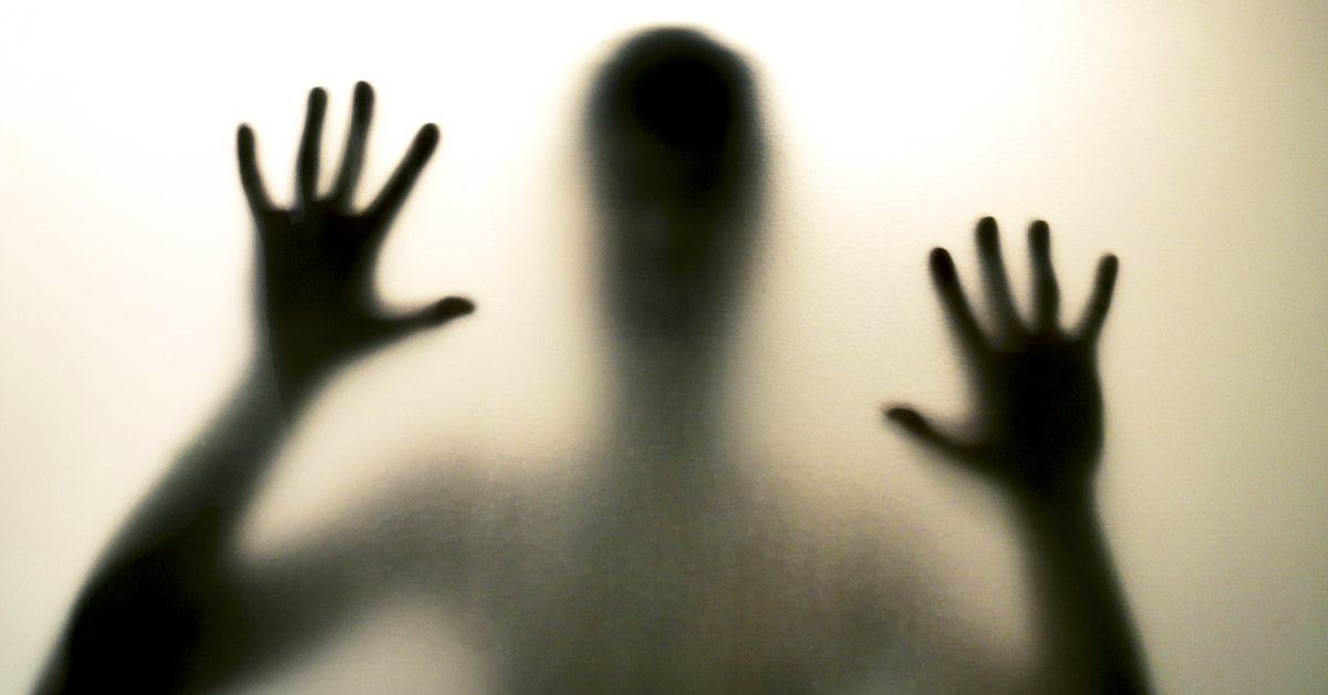Horror man behind the matte glass in black and white. Blurry hand and body figure abstraction. Halloween background. Murder concept. Criminal concpet.
