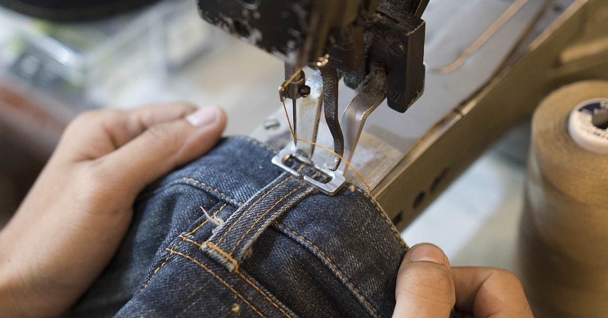 jeans being sewn together using sewing machine