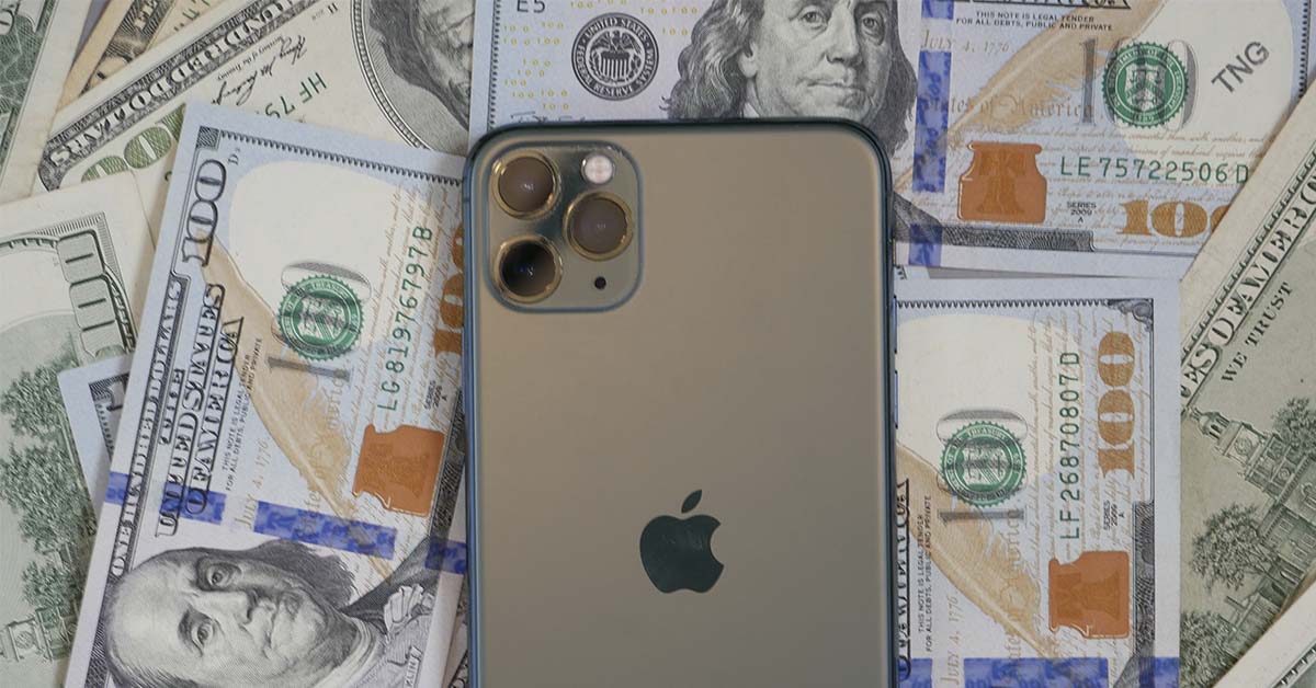 Apple phone sitting on top of American cash