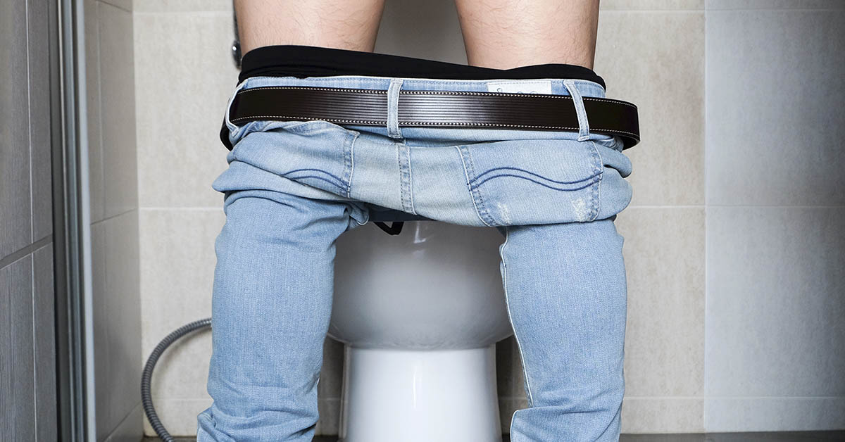 pants around knees peeing into toilet
