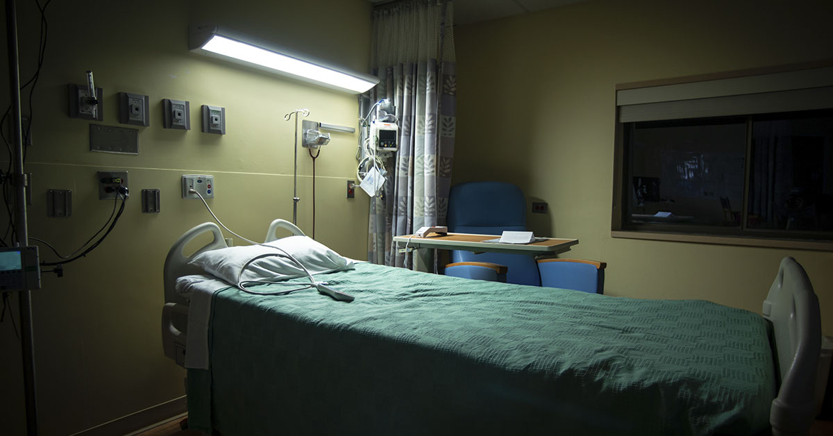 empty hospital bed in dimly lit room