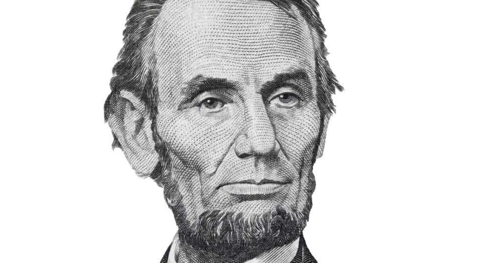 President Abraham Abe Lincoln face portrait on 5 dollar bill isolated, five usd, US money closeup
