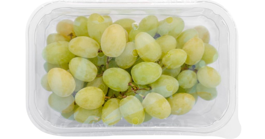 grapes in a plastic box in a cellophane wrapper on white background . Packaging template mockup .