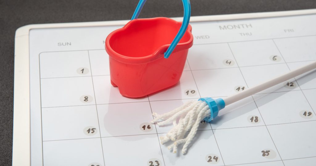 Small bucket and mop on the calendar. Concept of general cleaning