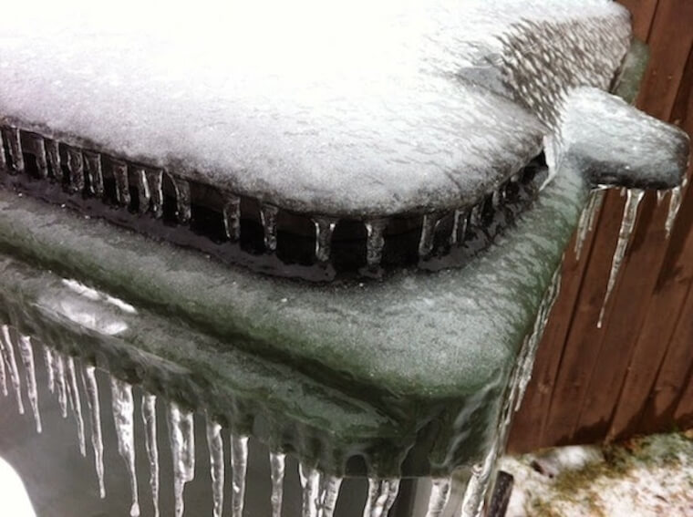 A frozen trash can with icicles