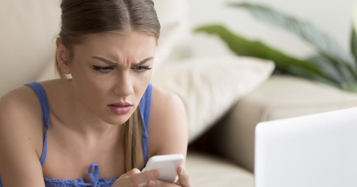 woman concerned looking at smartphone