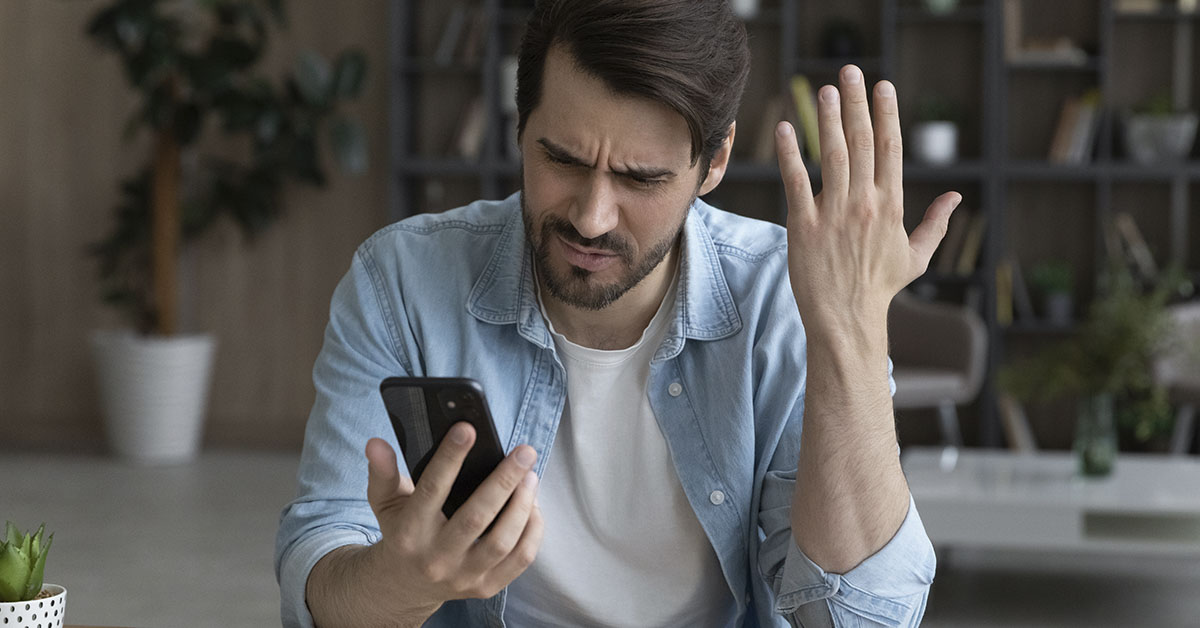 confused and puzzled man looking at smartphone