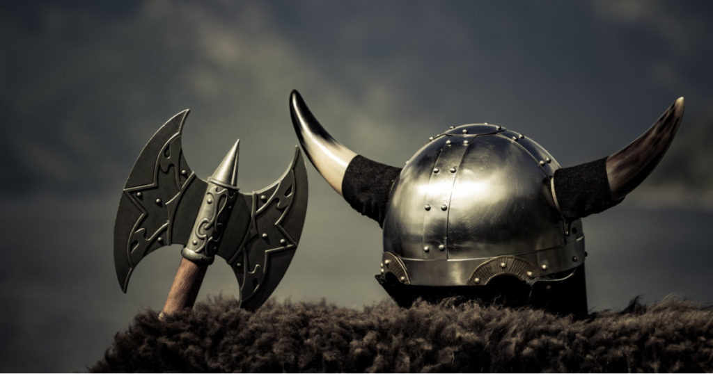 Viking helmet with axe on fjord shore in Norway. Tourism and traveling concept
