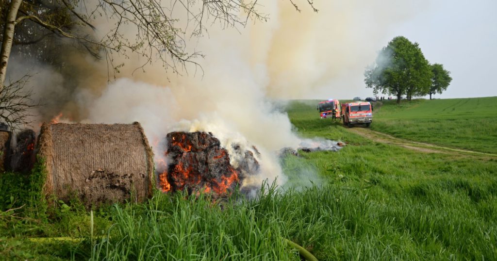Ostrava, Czech republic - may 2 2014: Fire trucks and firefighters at the site of a fire of dry hay bales in the fields outside the city
