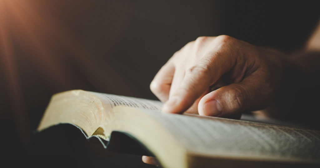 Close-up of woman's hands while reading the Bible.
