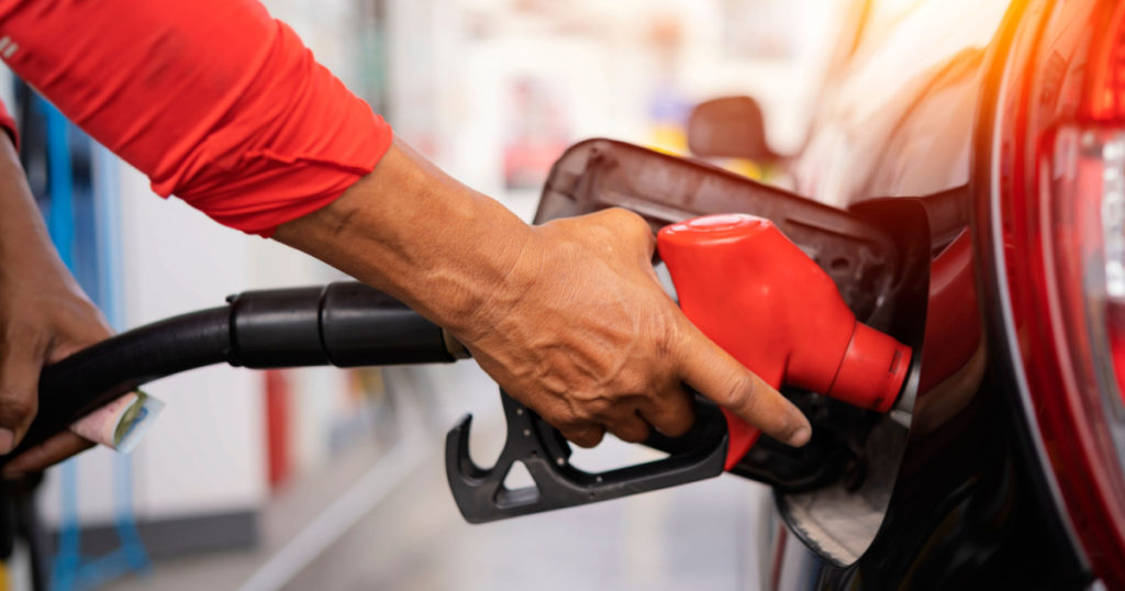 Refueling the car at a gas station fuel pump. Man driver hand refilling and pumping gasoline oil the car with fuel at he refuel station. Car refueling on petrol station. Fuel pump at station
