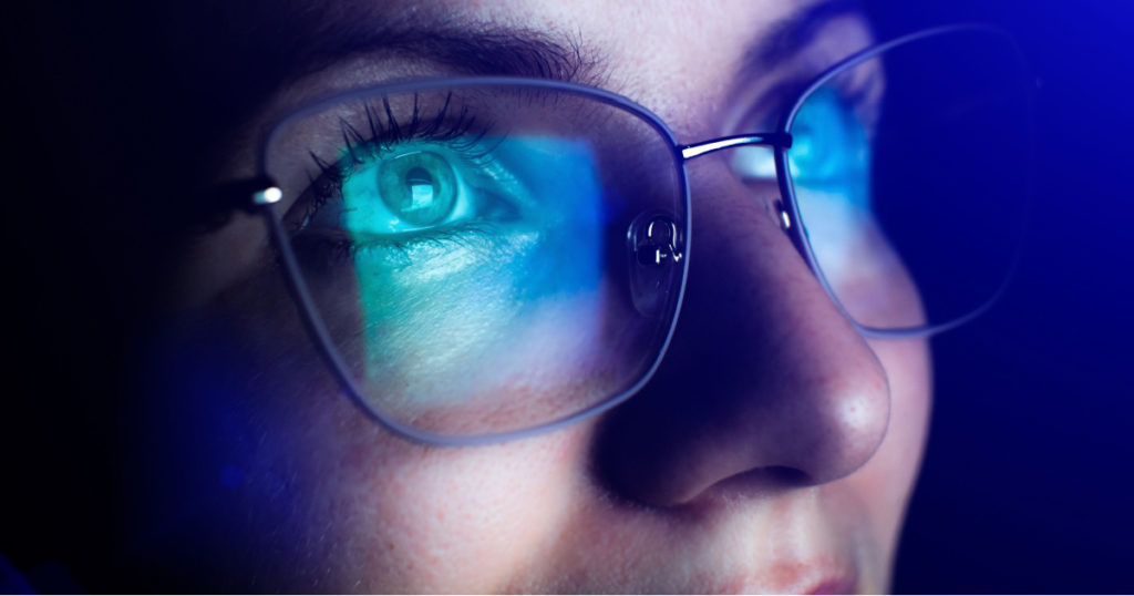 Girl works on internet. Reflection at the glasses from laptop. Close up of woman's eyes with black female glasses for working at a computer. Eye protection from blue light and rays.
