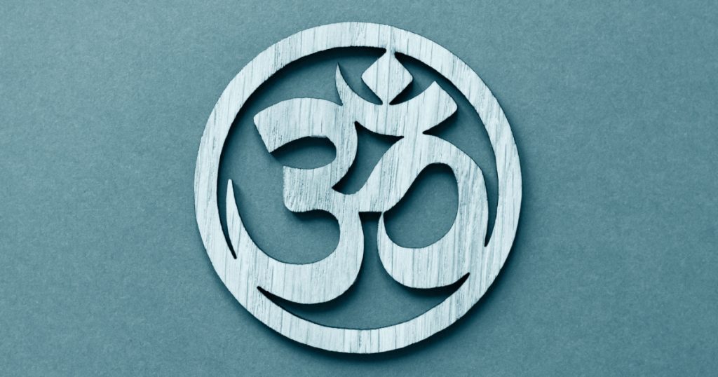 Om or Aum symbol of Hinduism and Buddhism on blue background 