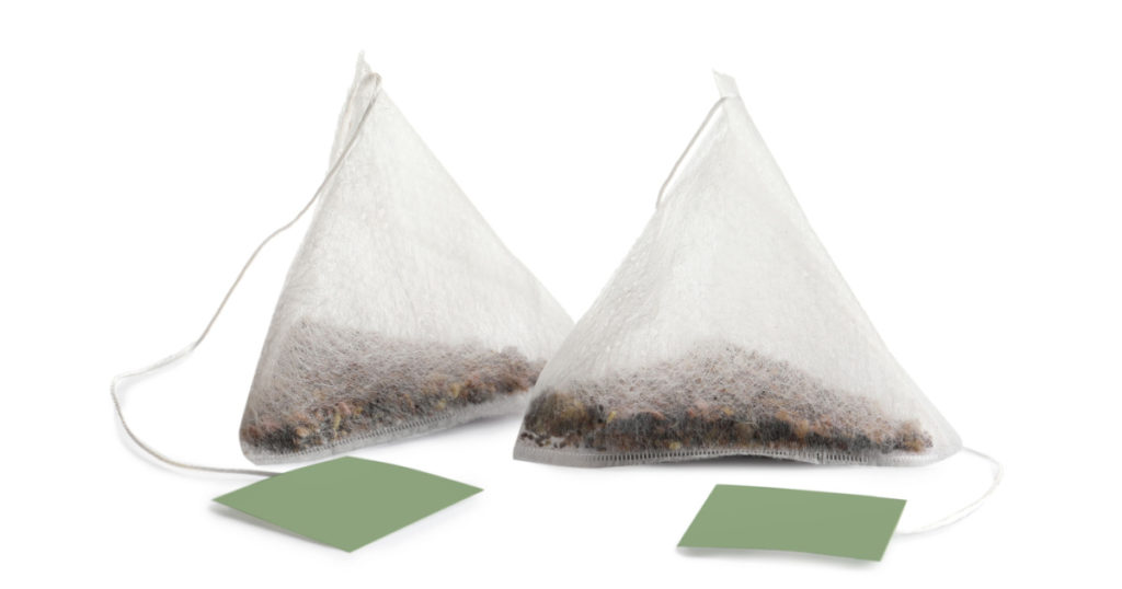 New pyramid tea bags on white background
