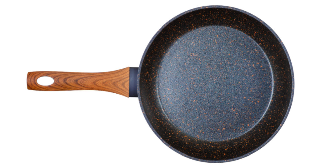 Black granite pan on white background isolation, top view
