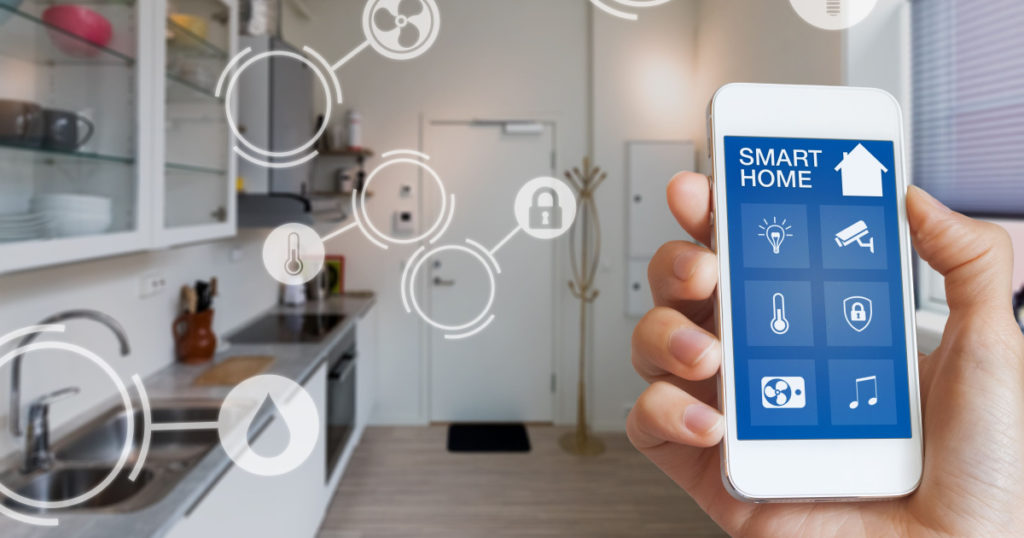 Smart home technology interface on smartphone app screen with augmented reality (AR) view of internet of things (IOT) connected objects in the apartment interior, person holding device
