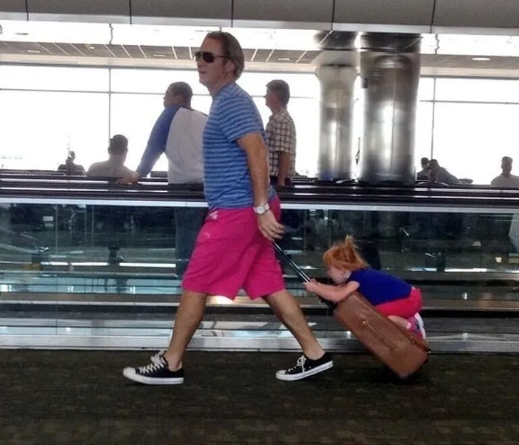 child on suitcase in airport