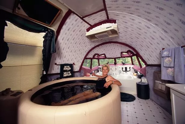Jo Ann Ussery relaxes in a hot tub in the cockpit of her plane