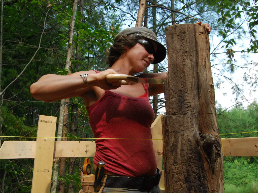 A photo of Bogwalker working on the logs of her cabin.