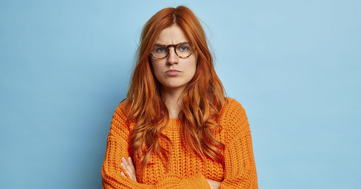 disgruntled woman in orange sweater