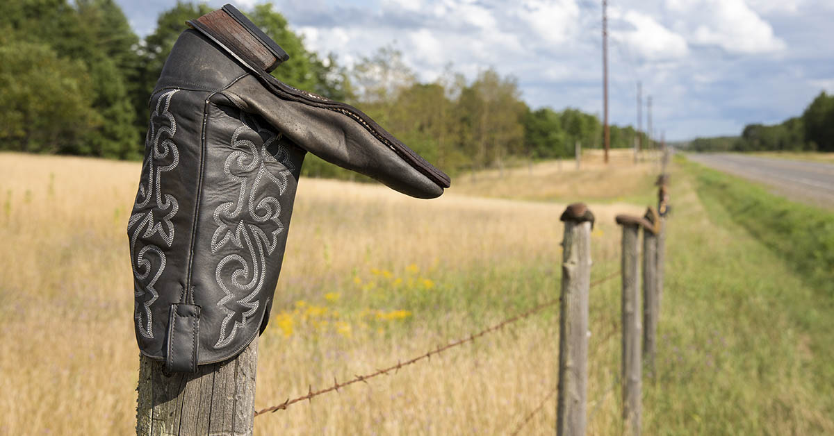 Cowboy boot on a fence
