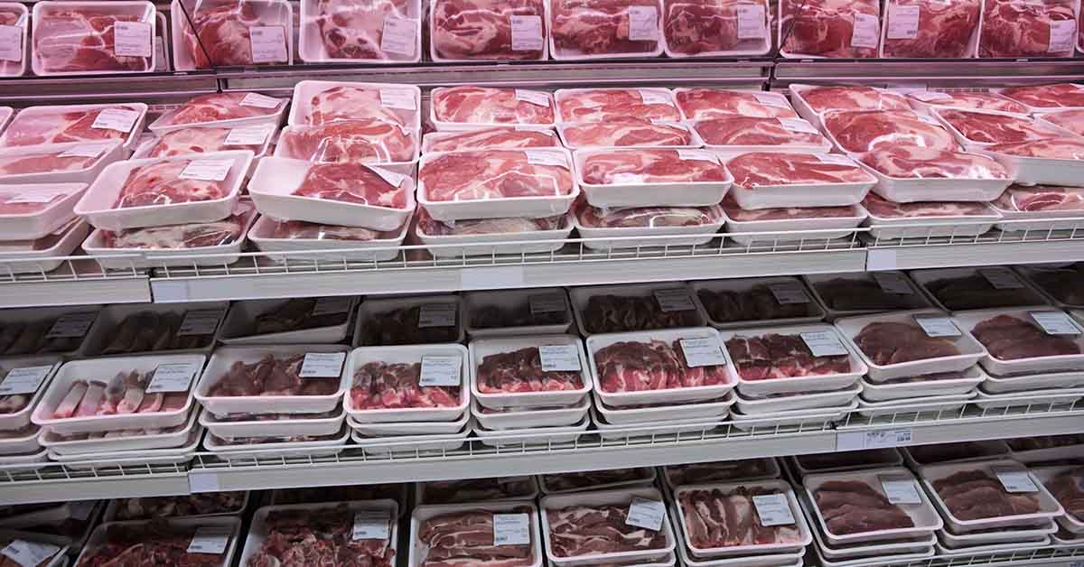 various cuts of red meat in refrigerated area at grocery store