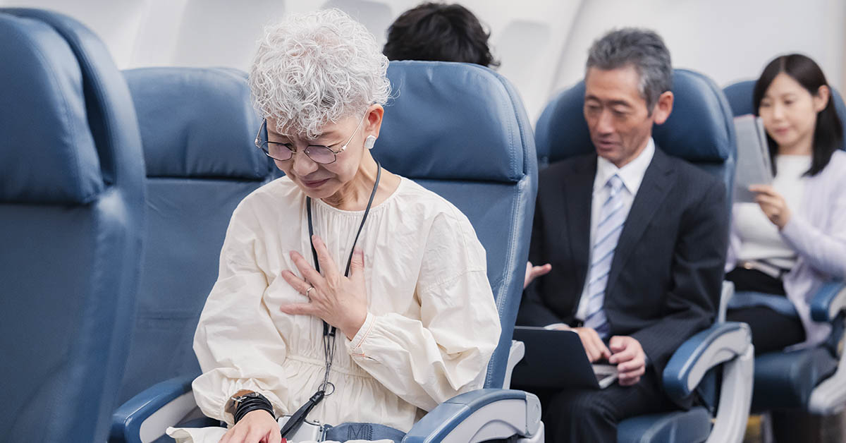 passenger on plane holding chest