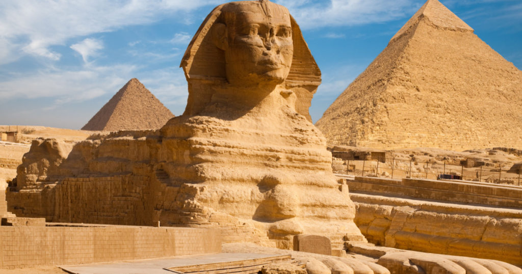 Beautiful profile of the Great Sphinx including pyramids of Menkaure and Khafre in the background on a clear sunny, blue sky day in Giza, Cairo, Egypt
